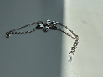 Silver bracelet with floral designs on a gray background