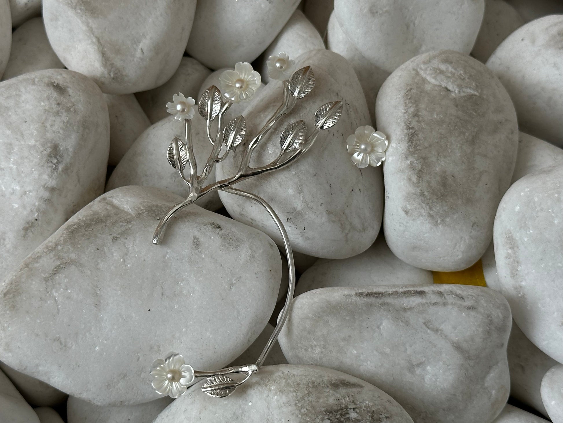Silver earcuff with floral design on pebbles