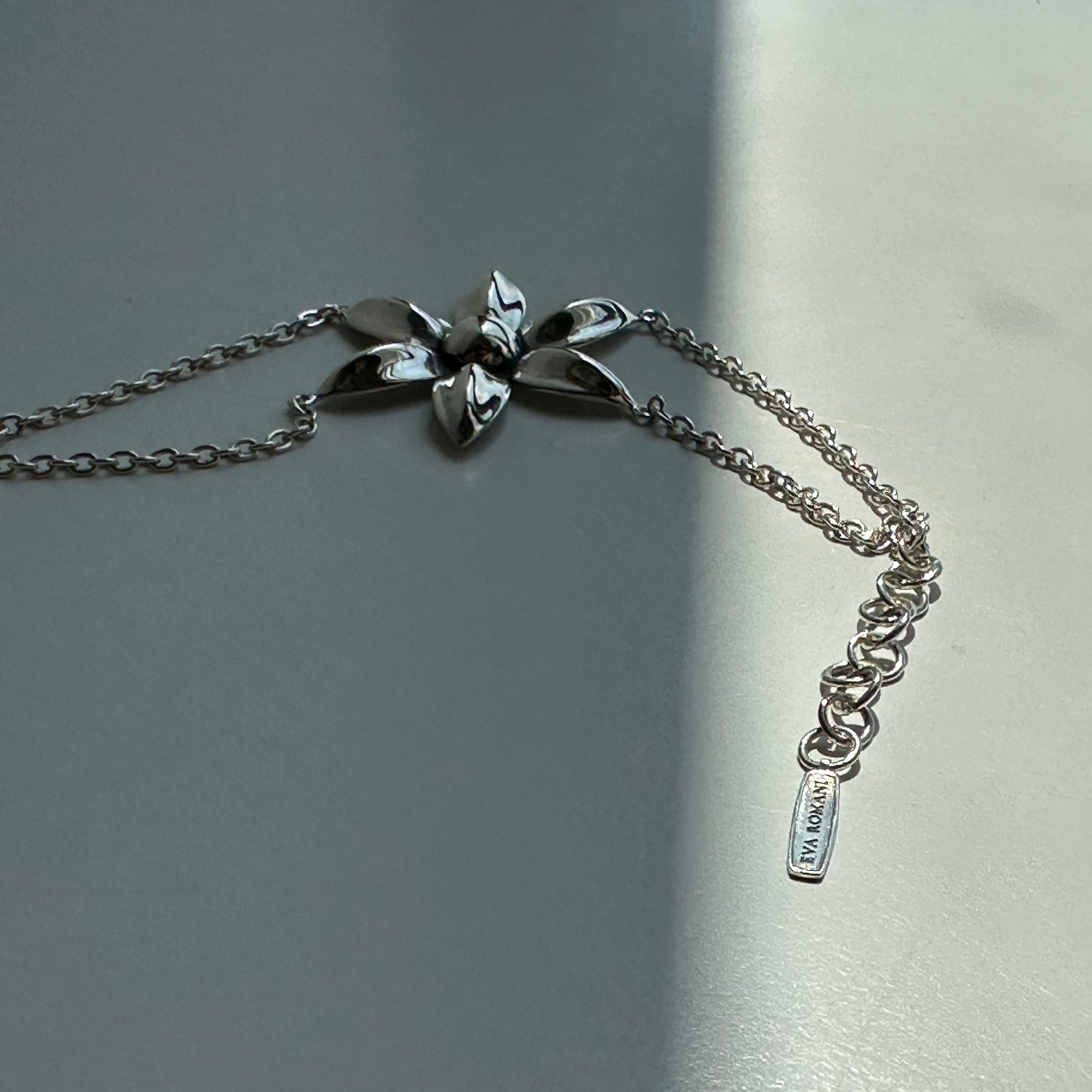 Silver bracelet with floral designs on a gray background