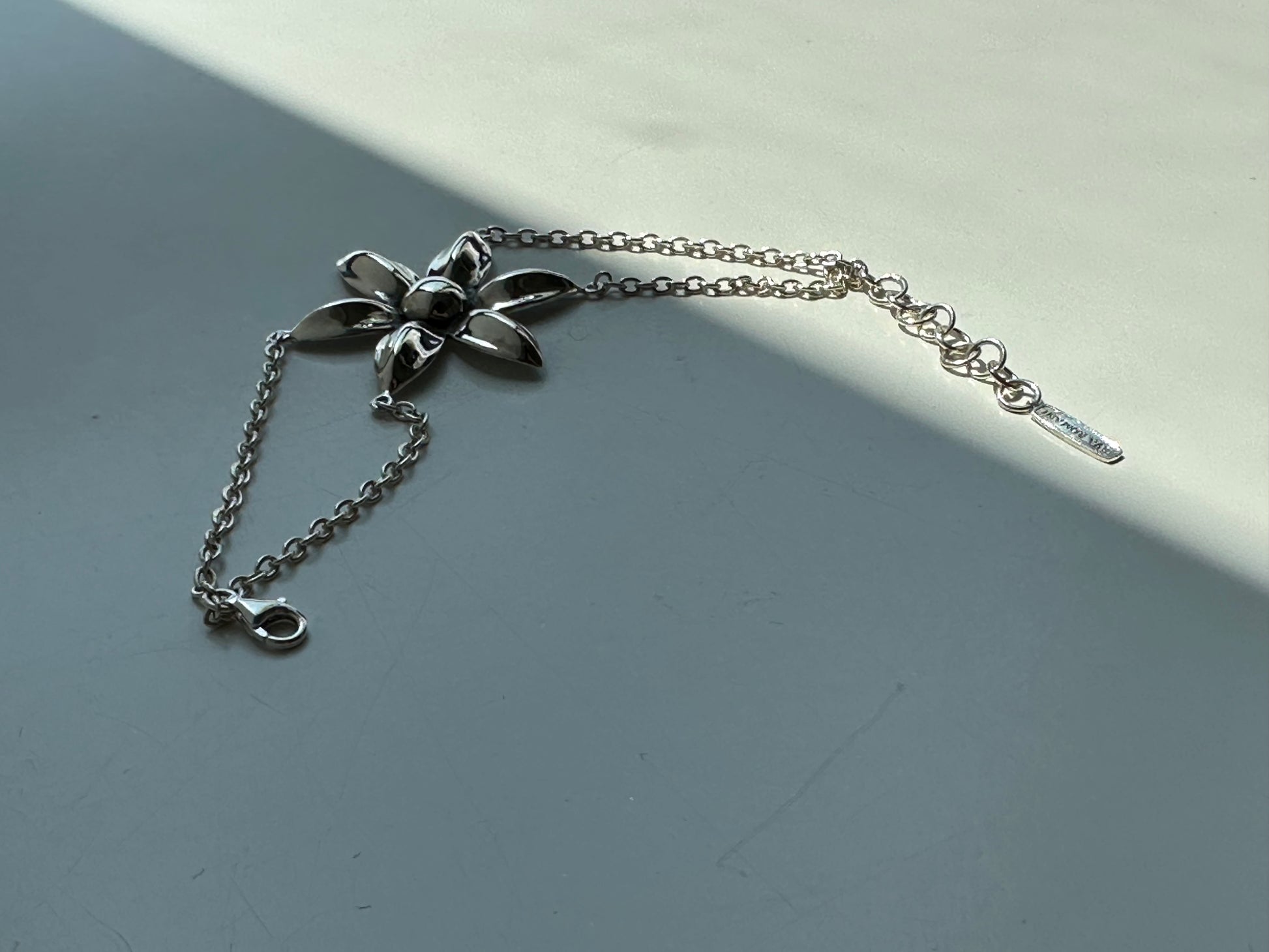 Silver bracelet with a floral design on a gray surface
