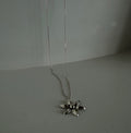Silver flower pendant necklace on a plain background